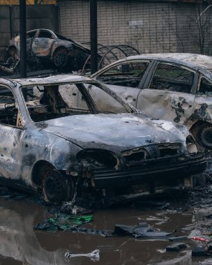 Bombardıman yüzünden sel basmış bir dizi yanmış sivil araç. Savaş bölgesindeki araçların ve kentsel çevrenin geniş çaplı tahribatı. Savaş sonrası dramatik bir bakış açısı..