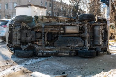 Şehir caddesindeki bir kazadan sonra altın rengi bir SUV yan yattı. Görüntüler aracın alt kısmını gösteriyor, egzoz sistemi ve yedek lastik de dahil. Kaza şehirde meydana geldi..