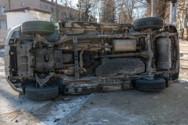 Şehir caddesindeki bir kazadan sonra altın rengi bir SUV yan yattı. Görüntüler aracın alt kısmını gösteriyor, egzoz sistemi ve yedek lastik de dahil. Kaza şehirde meydana geldi..