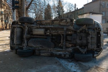 Şehir caddesindeki bir kazadan sonra altın rengi bir SUV yan yattı. Görüntüler aracın alt kısmını gösteriyor, egzoz sistemi ve yedek lastik de dahil. Kaza şehirde meydana geldi..