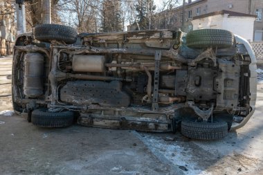 Şehir caddesindeki bir kazadan sonra altın rengi bir SUV yan yattı. Görüntüler aracın alt kısmını gösteriyor, egzoz sistemi ve yedek lastik de dahil. Kaza şehirde meydana geldi..