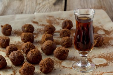 Küçük bardak konyak ve ev yapımı ahşap masa şekerler
