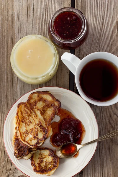 Una taza de té, un plato de panqueques. mermelada, cariño — Foto de Stock