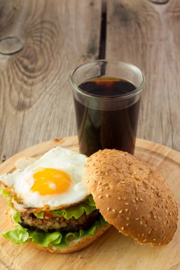 Burger sahanda yumurta ve bardak kola