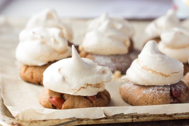 Shortbread cookies with peanut and meringues on cooking paper clipart