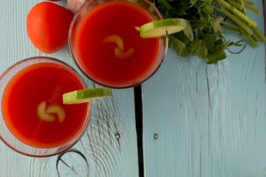 Mavi ahşap masa üzerinde bardaklarda domates gaspaço