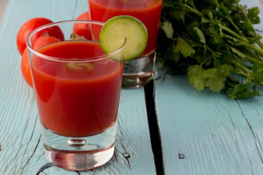 Mavi ahşap masa üzerinde bardaklarda domates gaspaço