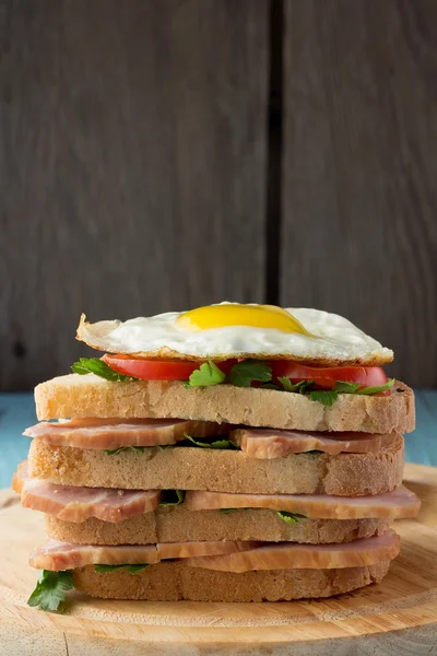 Сэндвич с копченой свининой, помидорами и яичницей — стоковое фото