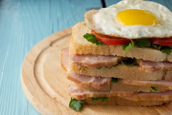 Сэндвич с копченой свининой, помидорами и яичницей — стоковое фото