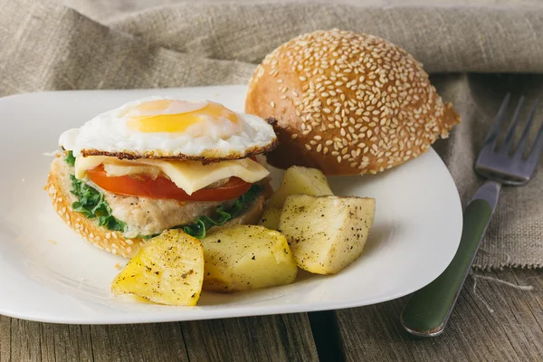 Чизбургер с яичницей и картофельными клинками — стоковое фото