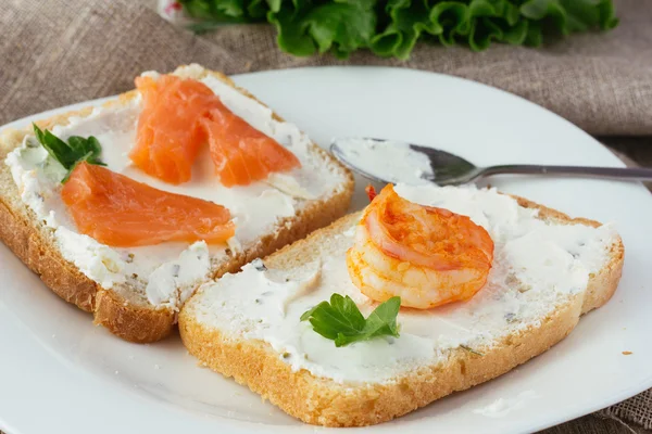 Toast aus Weizenbrot mit Frischkäse, Räucherlachs und Garnelen — Stockfoto