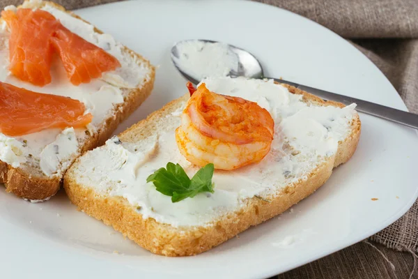 Toast aus Weizenbrot mit Frischkäse, Räucherlachs und Garnelen — Stockfoto