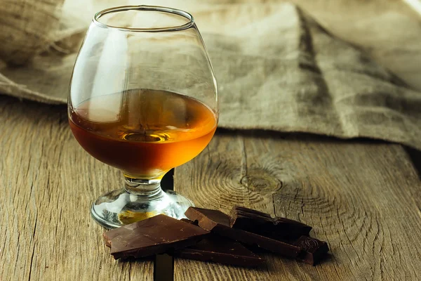 Cognac glas en chocolade Stockfoto
