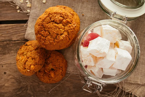 Oatmeal biscuits and jar with sweeties top view — Stock Photo, Image