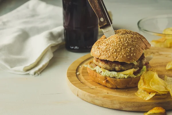 Cuchillo en hamburguesa con queso, cola y patatas fritas — Foto de Stock