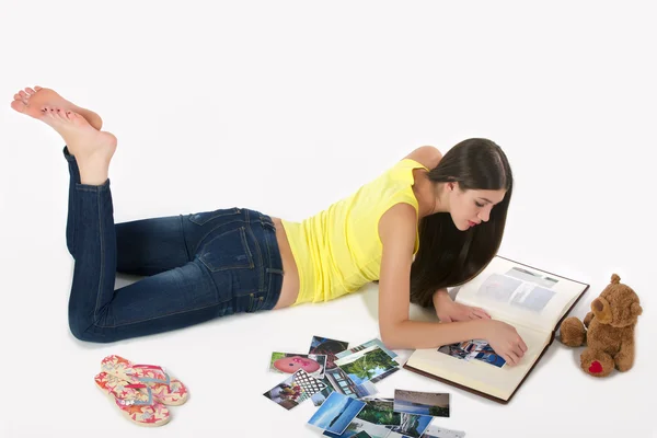 Chica con un álbum de fotos tumbado en el suelo — Foto de Stock