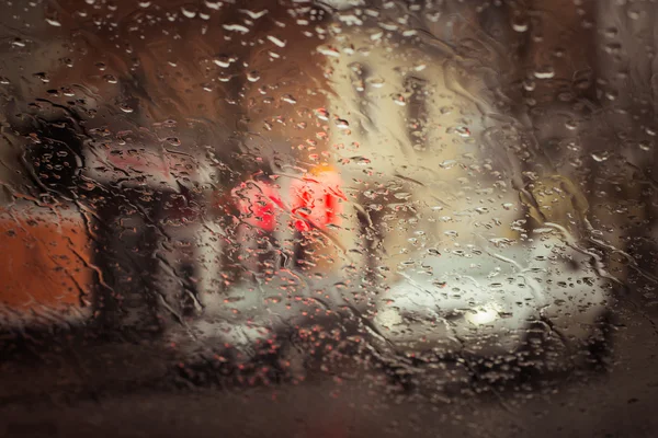 Rainy cidade rua vista através do pára-brisas carro — Fotografia de Stock