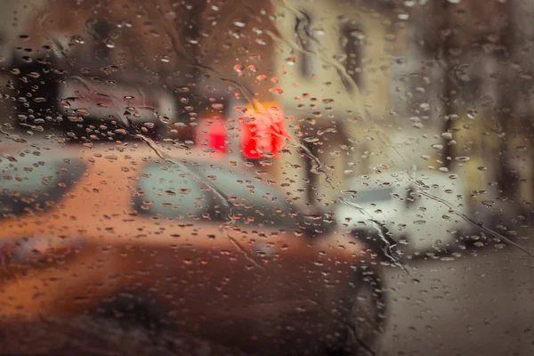 Rue de la ville pluvieuse vue à travers le pare-brise de voiture — Photo