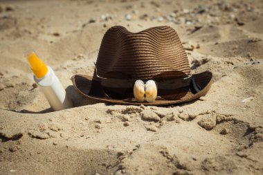 Kabukları ve bir şapka ve güneş koruyucu losyon bir şişe üzerinde güneş gözlüğü 