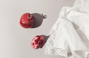 Beyaz kumaş zemininde taze nar var. Kartlar, bloglar, posterler ve web tasarımı için güzel bir zemin. Seçici odaklanma. Mimal biçim