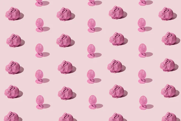 Easter pattern made of pink glittering eggs and bunny on pastel background. Festive concept