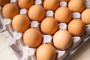 Tahta masadaki karton kutuda tavuk yumurtası. Yaklaş...