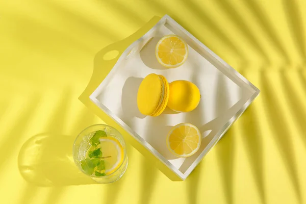 Κίτρινα Μακαρόν Λεμόνια Λευκό Δίσκο Και Ένα Ποτήρι Λεμονάδα Στο — Φωτογραφία Αρχείου