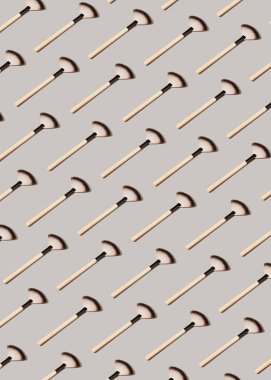 Pastel gri arka planda makyaj fırçalarıyla yaratılmış yaratıcı desen. Dekoratif kozmetik ve makyaj konsepti. Asgari biçim bileşimi.