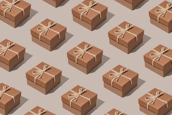Creative pattern made with present boxes with bows on pastel background. Christmas or birthday gift concept. Minimal style.