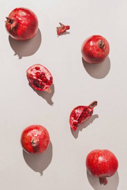 Pastel gri arka planda taze nar ve güneş ışığı. Asgari düzeyde. Üst Manzara. Düz yatıyordu .