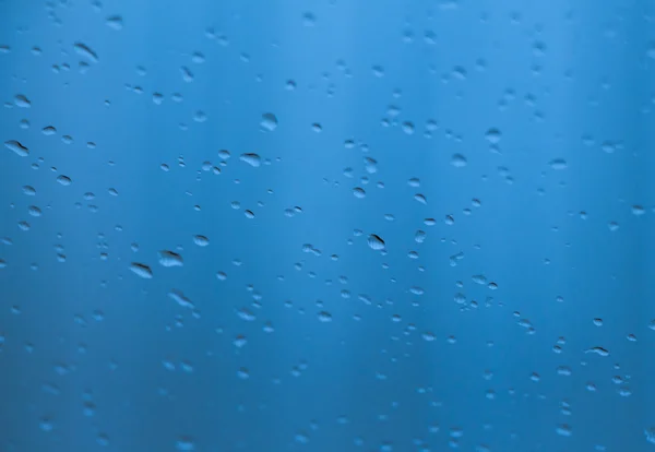 Gocce d'acqua su una superficie di vetro come sfondo — Foto Stock