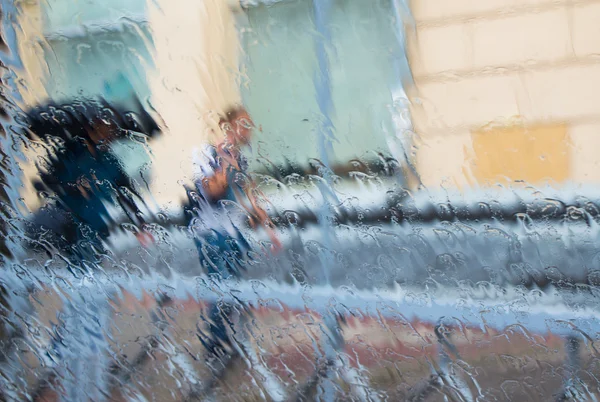 Σιλουέτες των δύο ανθρώπων κάτω από τη βροχή, ιδωμένη μέσα από την υγρή παράθυρο — Φωτογραφία Αρχείου