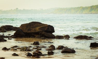 Arka plan dalgalar ile bir okyanusta defne kayalar 