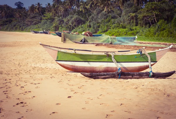 Balıkçı teknesi backgrou palmiye ağaçları ile tropikal bir plajda