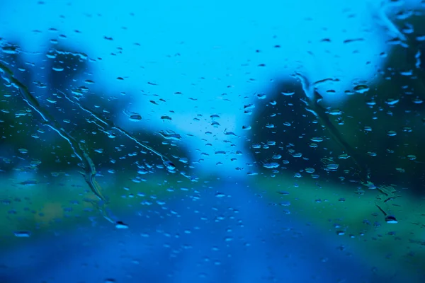 Road seen through water drops on the car windshield — Stock Photo, Image