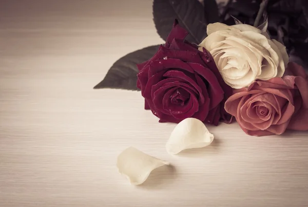 Las rosas sobre una mesa se cierran. Estilo vintage efecto tonificado —  Fotos de Stock
