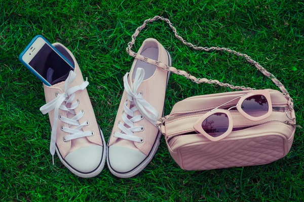 Spor ayakkabı, cep telefonu, cüzdan ve güneş gözlüğü