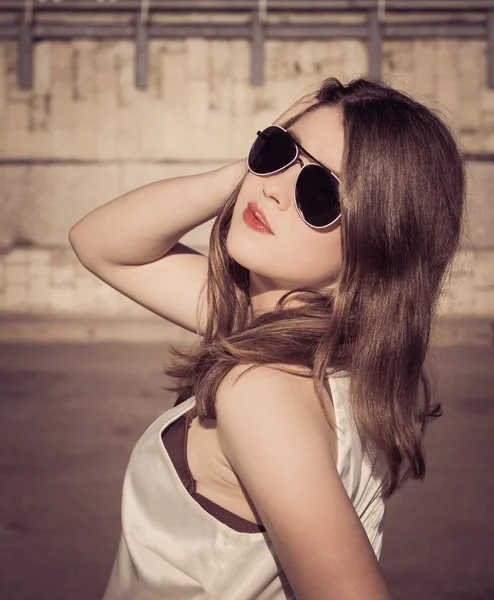 Porträtt av en snygg tjej i solglasögon i en stad — Stockfoto