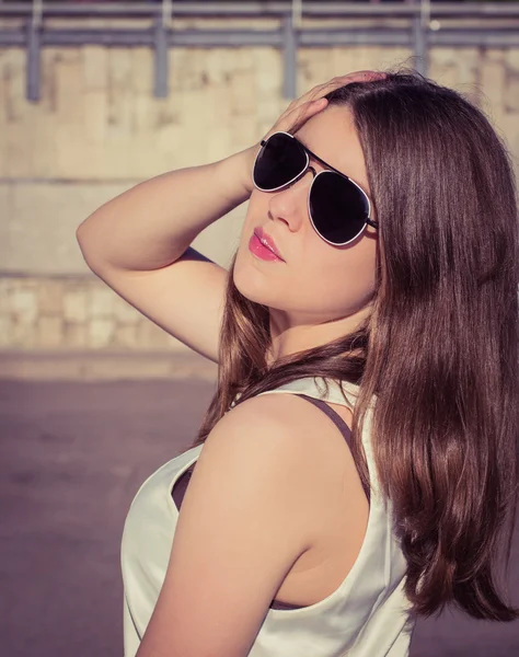 Retrato de una chica con estilo en gafas de sol en una ciudad — Foto de Stock