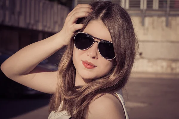 Retrato de una chica con estilo en gafas de sol en una ciudad — Foto de Stock