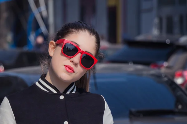 Retrato de cerca de una chica con estilo en gafas de sol rojas — Foto de Stock