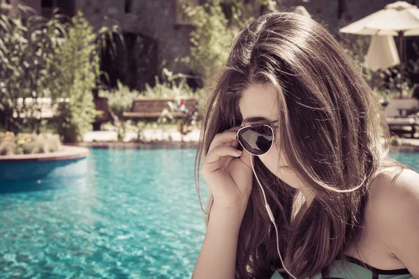 Güneş gözlüğü ve kulaklık müzik bir SWI yakınındaki bir kızla