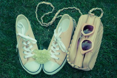 Güneş gözlüğü ve çanta, yeşil çim ile beyaz gül desenli spor ayakkabı