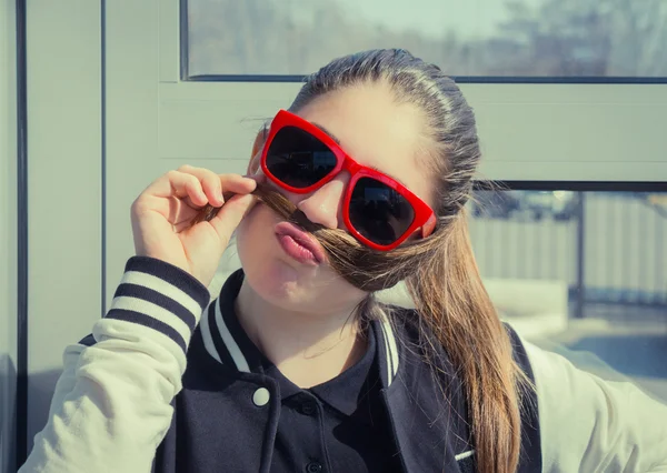 Portrait d'une adolescente drôle en lunettes de soleil rouges — Photo