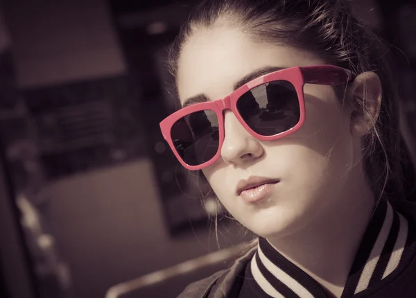Retrato de cerca de una chica con estilo en gafas de sol en una ciudad stre — Foto de Stock
