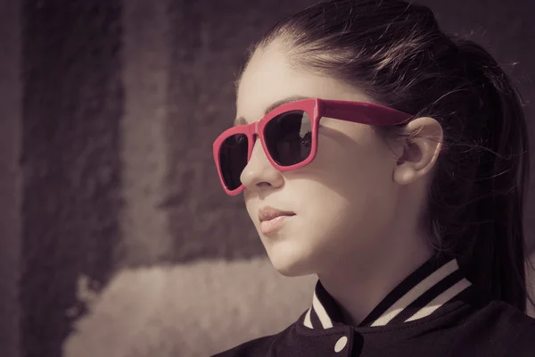 Retrato de cerca de una chica con estilo en gafas de sol en una ciudad stre — Foto de Stock