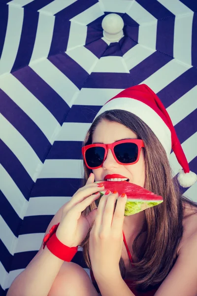 Retrato de uma menina sorrindo engraçado em chapéu de Papai Noel e vermelho cantado — Fotografia de Stock