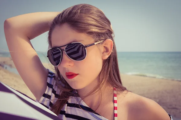 Retrato de uma menina elegante em uma camiseta listrada e óculos de sol b — Fotografia de Stock