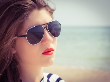 Portre yakın çekim bir genç kızın sahilde güneş gözlüğü