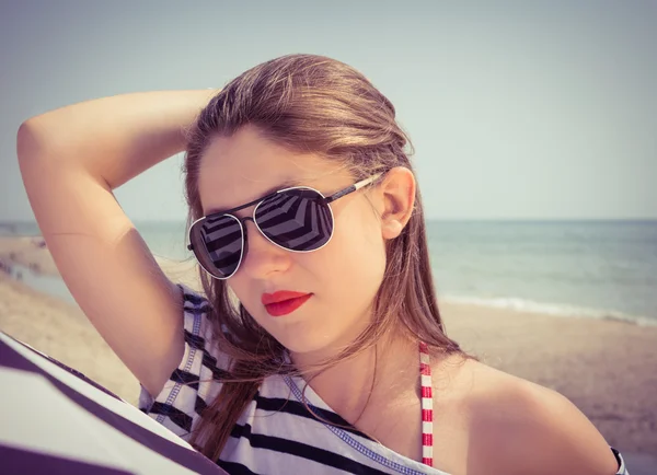 Egy csíkos pólót és napszemüveget b egy elegáns lány portréja — Stock Fotó